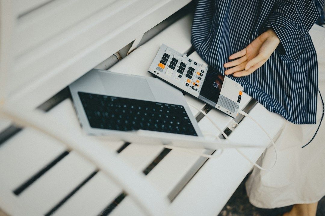 Laptop und elektronisches Musikgerät neben einer musizierenden Person